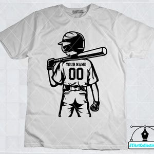 May include: White t-shirt with a black and white illustration of a baseball player holding a bat. The player is wearing a baseball cap and has the text "YOUR NAME 00" on the back of their jersey.