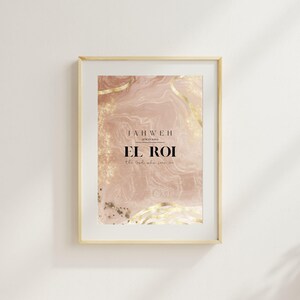 Op de afbeelding: Ingelijste kunstdruk met de tekst "JAHWEH EL ROI the God who sees me". De achtergrond heeft een roze en gouden abstract ontwerp. De lijst heeft een lichte houtkleur.