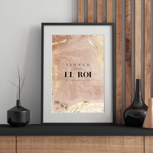 Op de afbeelding: Ingelijste kunstdruk met de woorden "JAHWEH EL ROI" in een stijlvol lettertype. De achtergrond heeft een zacht, gemarmerd effect in roze en gouden tinten. De print wordt gepresenteerd in een zwart frame, wat een vleugje elegantie toevoegt.