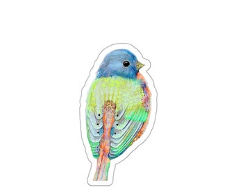 May include: A vibrant sticker depicting a watercolour illustration of a bird. The bird has a blue head, a yellow and green body, and a mix of green, orange, and blue on its wings and tail. The sticker is cut around the bird's outline.