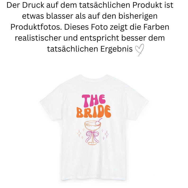 May include: White t-shirt with the text "THE BRIDE" in pink and orange retro font. Below the text is a cocktail glass design with a cherry, bow, and star accents. A bridal party theme.