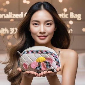 May include: A white quilted cosmetic bag with a pink and yellow flower design. The bag has a zipper closure and a plaid trim.