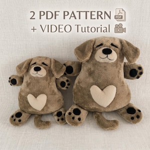May include: Two brown plush dog toys with floppy ears, black paw pads, and a cream-colored heart patch on the belly. The text 2 PDF PATTERN + VIDEO TUTORIAL is displayed above the toys, accompanied by a PDF icon and a video camera icon.
