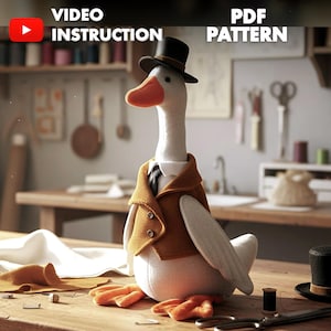Könnte beinhalten: Eine Stoffgans mit Miniaturzylinder, Weste und Krawatte. Die Gans hat orangefarbene Füße und einen Schnabel. Das Bild enthält den Text "VIDEO INSTRUCTION" und "PDF PATTERN". Die Gans sitzt auf einem Holztisch.
