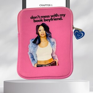 May include: Pink e-reader case with a zipper and a blue heart charm. The case features a graphic of a woman with the text "don't mess with my book boyfriend."