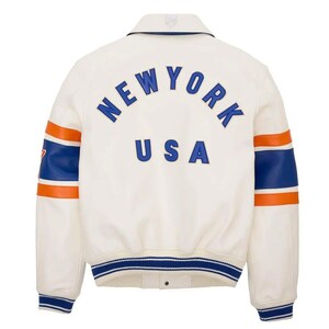 May include: Cream-colored varsity jacket with blue and orange accents. The back features the text "NEW YORK USA" in blue lettering. The sleeves have blue and orange stripes. The jacket has a collared neckline and a button-up front.