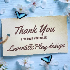 May include: A rectangular cream-colored paper tag with deckled edges featuring the dark brown text Thank You FOR YOUR PURCHASE Laventille Play design. The tag has a hole with a brown string and is decorated with two blue butterflies and white flowers.
