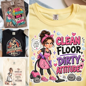 以下が含まれることがあります： 薄い黄色のTシャツ。お団子ヘアにピンクのヘッドバンド、ピンクのエプロンと手袋を着用し、ピンクの掃除機をかけている人物の漫画風イラストが描かれています。テキストは「Clean Floor, Dirty Attitude」と書かれており、泡やハートの装飾も含まれています。
