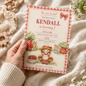 May include: A birthday invitation with a red and white gingham border. The invitation features the text "You are Invited!" and "Our Berry Sweet KENDALL is turning 1." The illustration includes a girl with baskets of strawberries.