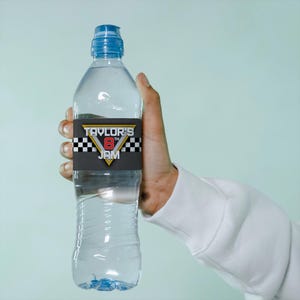 May include: A clear plastic water bottle with a blue lid and a black and white checkered label that says "Taylor's 8th Jam".