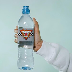 May include: A clear plastic water bottle with a blue cap and a label that says "Taylor's 8th Jam" with a checkered flag and flames design.