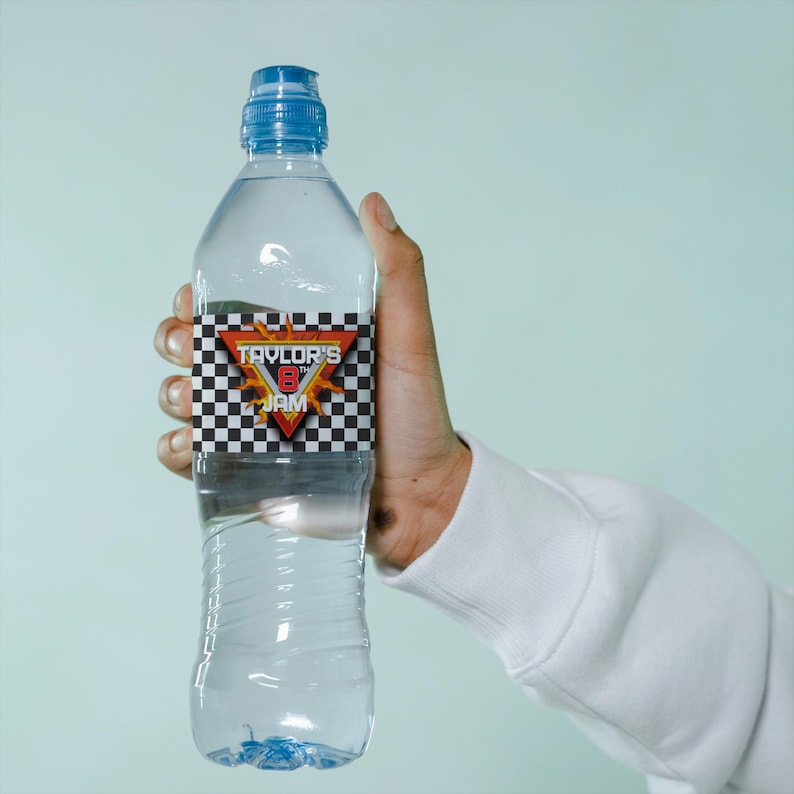 May include: A clear plastic water bottle with a blue cap and a label that says "Taylor's 8th Jam" with a checkered pattern and flames.