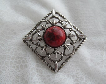 Sarah Coventry signed silver colored metal brooch with red cab for center