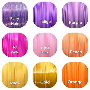 May include: Nine spools of 3D printing filament in various colors, including Fairy Hair, Indigo, Purple, Hot Pink, Light Pink, Peach, Yellow, Gold, and Orange. Each spool is labeled with its color name.