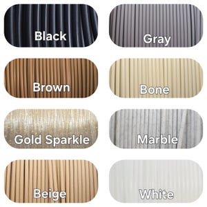 Peut inclure: Pr&eacute;sentation de bobines de filament de diff&eacute;rentes couleurs : noir, gris, marron, os, or scintillant, marbre, beige et blanc. Chaque bobine est &eacute;tiquet&eacute;e avec le nom de sa couleur en blanc.