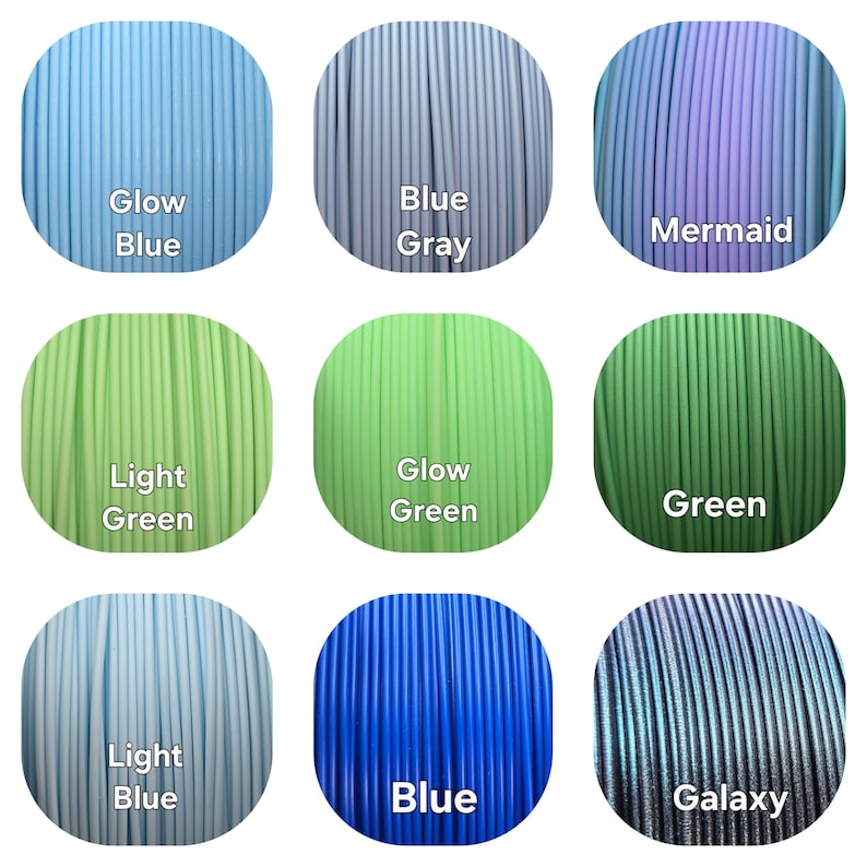 May include: Nine spools of 3D printer filament in various colors, including Glow Blue, Blue Gray, Mermaid, Light Green, Glow Green, Green, Light Blue, Blue, and Galaxy. Each spool is labeled with its color name.