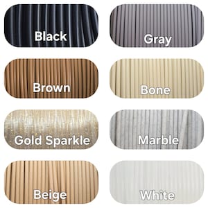 May include: A collection of eight spools of filament in various colors. Colors include black, gray, brown, bone, gold sparkle, marble, beige, and white. Each spool is labeled with its respective color name.