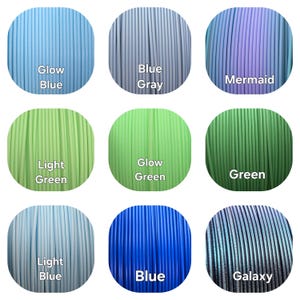 Peut inclure: Neuf bobines de filament pour imprimante 3D de diff&eacute;rentes couleurs, dont Glow Blue, Blue Gray, Mermaid, Light Green, Glow Green, Green, Light Blue, Blue et Galaxy. Chaque bobine est &eacute;tiquet&eacute;e avec son nom de couleur.