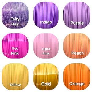 Peut inclure: Neuf bobines de filament d'imprimante 3D de diff&eacute;rentes couleurs, dont Fairy Hair, Indigo, Purple, Hot Pink, Light Pink, Peach, Yellow, Gold et Orange. Chaque bobine est &eacute;tiquet&eacute;e avec son nom de couleur.