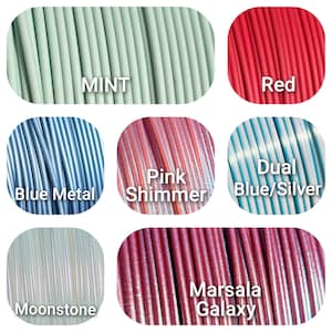 Peut inclure: Plusieurs bobines de filament d'impression 3D aux couleurs vari&eacute;es. Les couleurs comprennent menthe, rouge, bleu m&eacute;tal, rose scintillant, bleu/argent&eacute;, pierre de lune et marsala galaxy. Chaque bobine est &eacute;tiquet&eacute;e avec son nom de couleur en texte blanc.