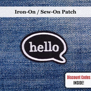 May include: A black and white "hello" patch in a speech bubble shape, with the text "Iron-On / Sew-On Patch" above. The patch is on a blue denim background. A small white rectangle with the text "Discount Codes INSIDE!" is in the bottom right corner.