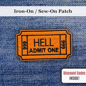 Puede incluir: Un parche termoadhesivo naranja con forma de boleto, con el texto "HELL ADMIT ONE" en negro. Los números "666" están a cada lado. El parche está sobre un fondo de mezclilla azul. El texto "Iron-On / Sew-On Patch" está en la parte superior.