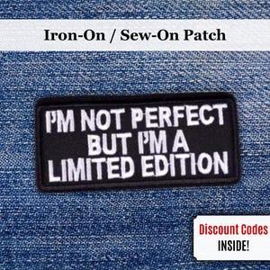 Puede incluir: Parche rectangular negro con texto blanco: "I'M NOT PERFECT BUT I'M A LIMITED EDITION." El parche es para planchar o coser. El fondo es de mezclilla azul. Un pequeño rectángulo blanco con el texto "Discount Codes INSIDE!" está en la esquina inferior derecha.