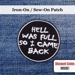 May include: A black, circular iron-on patch with white text that reads "HELL WAS FULL SO I CAME BACK." The patch is set against a blue denim background. The words "Iron-On / Sew-On Patch" are at the top.