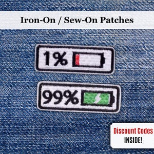 Puede incluir: Dos parches rectangulares para planchar con bordes negros. El parche superior muestra una batería al 1% con relleno rojo, y el parche inferior muestra una batería al 99% con relleno verde y un rayo. El texto "Iron-On / Sew-On Patches" está en la parte superior.