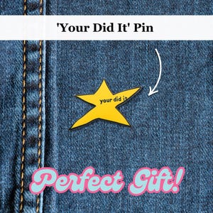 Può includere: Uno spillo a forma di stella gialla con il testo "you did it" su uno sfondo in denim. Il testo "Perfect Gift!" è scritto in lettere rosa e blu sotto lo spillo.
