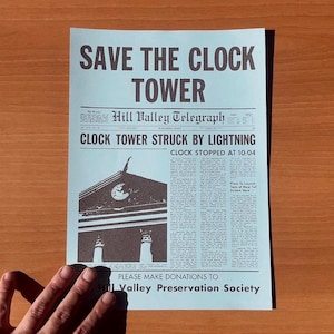 Puede incluir: Un titular de periódico azul y blanco dice "Salve la Torre del Reloj" con una ilustración en blanco y negro de una torre del reloj. El periódico se titula "Hill Valley Telegraph" y el titular dice "Torre del Reloj golpeada por un rayo". El texto debajo del titular dice "Reloj detenido a las 10:04".