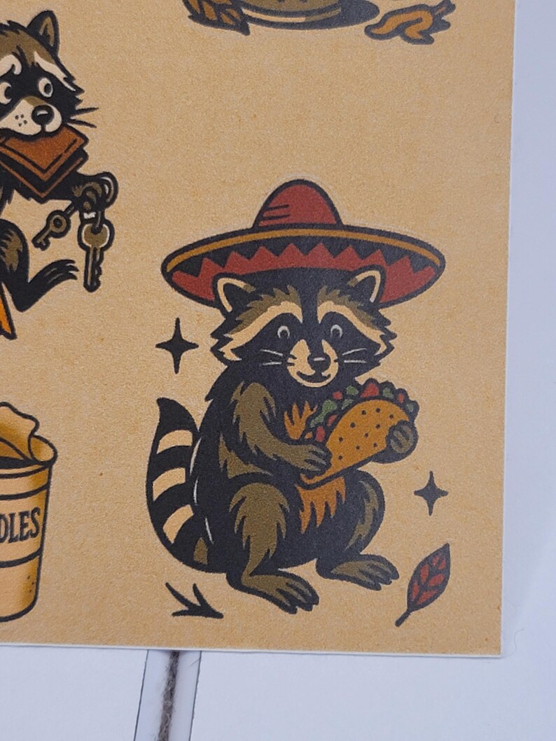 May include: A raccoon wearing a red and brown sombrero, holding a taco. The raccoon is brown and black with a striped tail. The image has a vintage tattoo style with star and leaf accents.