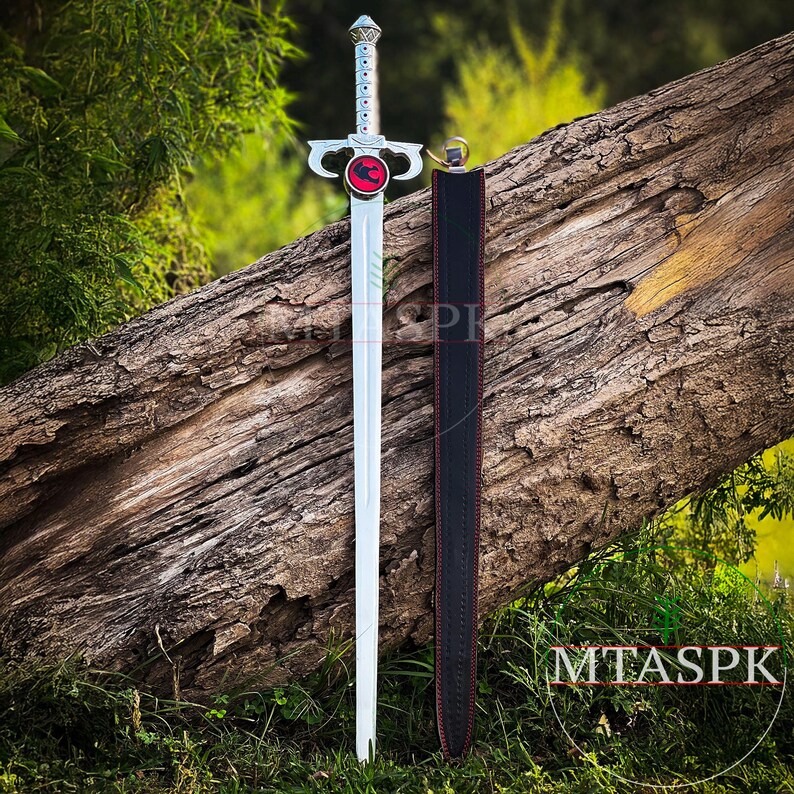 May include: A silver sword with a red and black dragon emblem on the pommel. The sword is displayed with a black leather scabbard.