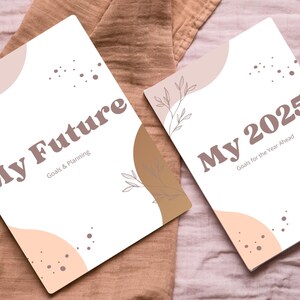 May include: Two white journals with brown and peach abstract designs. The larger journal has the text "My Future" and "Goals & Planning". The smaller journal has the text "My 2025" and "Goals for the Year Ahead".