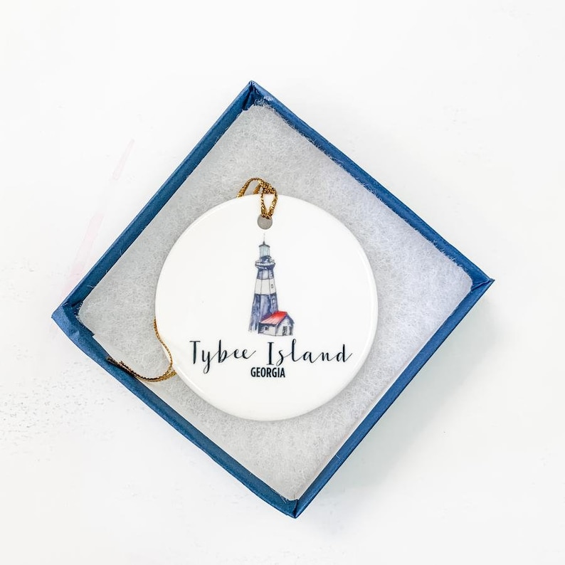 Puede incluir: Adorno de cer&aacute;mica blanca con una ilustraci&oacute;n de acuarela del faro de Tybee Island en Georgia. El adorno tiene una cuerda dorada para colgar.
