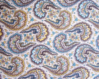 May include: A white fabric with a paisley pattern in shades of blue, brown, and yellow.