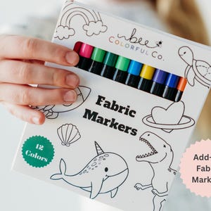 Close-up image of a girl holding Bee Colorful Co. fabric markers. Includes graphic 'Add-On Fabric Markers'.