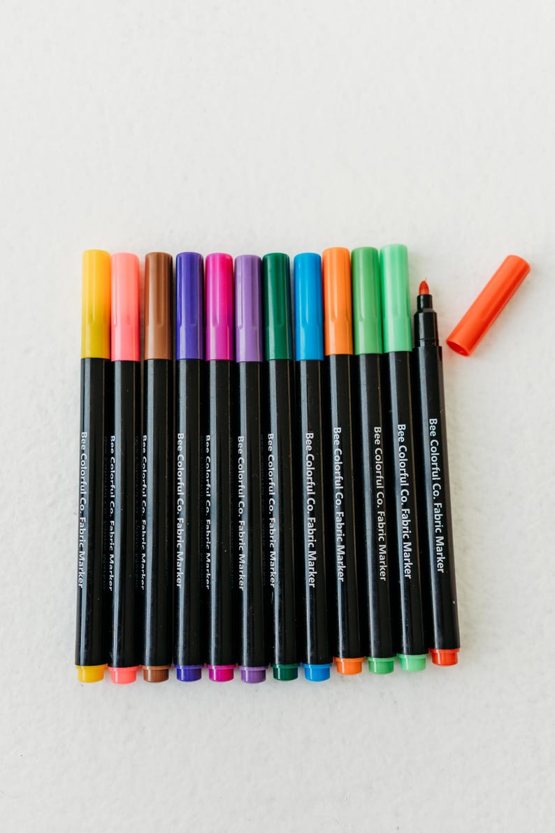 Bee Colorful Co. fabric marker set: 12 rainbow colors. Non-toxic, permanent pens for kids' coloring pajamas, t-shirts, canvas & fabric crafts. Fine tips for detailed designs. Perfect for DIY projects, personalized gifts, and fabric art. ASTM D-4236 certified, ensuring safety for children. Use on clothes, textiles, and apparel for lasting color and creative play. Enhance any project with these easy-to-use, vibrant markers.