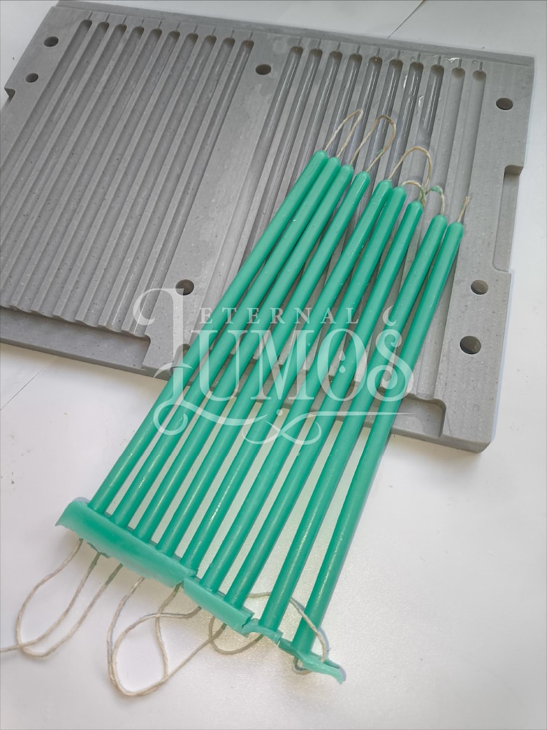 May include: A set of teal-colored taper candles with wicks, resting on a gray candle mold. The candles are grouped together, ready for use. The image includes the text "ETERNAL LUMOS".