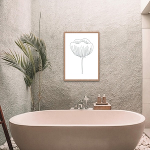 May include: A white bathroom with a freestanding bathtub, a wooden ladder, and a framed black and white line drawing of a flower.