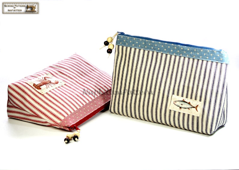 May include: Two striped fabric zippered pouches with different designs. The pouch on the left is red and white striped with a lobster design. The pouch on the right is blue and white striped with a fish design.