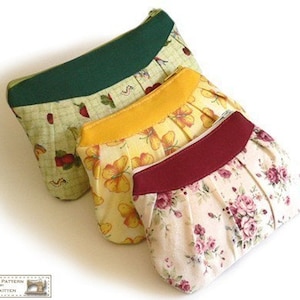 May include: Three fabric zippered pouches with different floral patterns. The pouches are green, yellow, and cream with red accents.