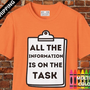 May include: Orange t-shirt with a white clipboard graphic that reads "ALL THE INFORMATION IS ON THE TASK." The shirt also has a crayon graphic with the words "MULTIPLE COLORS."
