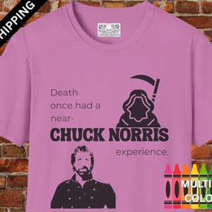 May include: A pink t-shirt with a black graphic of Chuck Norris and the text "Death once had a near-Chuck Norris experience."