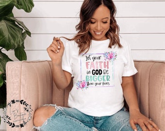 May include: White t-shirt with a floral design and the text "Let your faith in God be bigger than your fears".