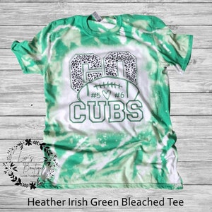 K&ouml;nnte beinhalten: Gr&uuml;n-wei&szlig;es Batik-T-Shirt mit einem wei&szlig;en Football-Motiv und dem Text "Go Cubs #5 #6" in Schwarz.