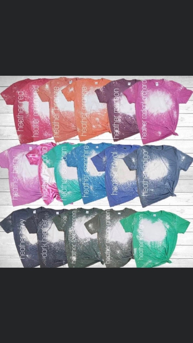 May include: A collection of 14 t-shirts in various heather colors, each with a bleach-splattered design. The colors include red, cardinal red, bronze, orange, maroon, radiant orchard, berry,  navy, dark heather,  sealoam, sapphire, royal, indigo, forest green, military green, and Irish green.