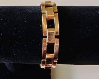 May include: A gold-toned bracelet with a chain link design. The bracelet is made of metal and has a polished finish.