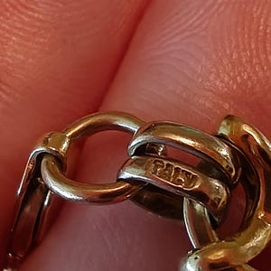 May include: Close-up of a gold chain with a hallmark that reads "ITALY".
