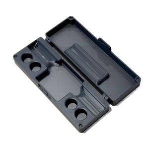May include: A dark gray rectangular storage case with a hinged lid, featuring a molded interior with four circular cutouts on one side and a long recessed channel, designed for organizing small items within its structured, partitioned compartments.